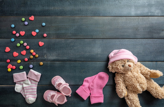 Baby girl shoes and socks on blue wooden background