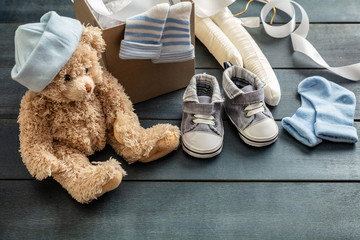 Baby boy shoes and socks on blue wooden background