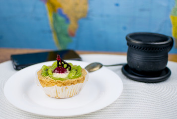 A cake, a cup of coffee and a phone.