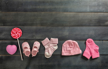 Baby girl shoes and socks on blue wooden background