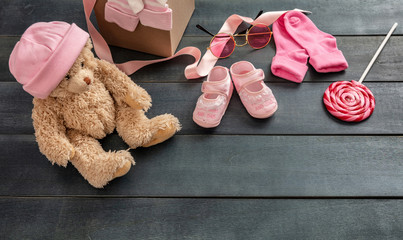 Baby girl shoes and socks on blue wooden background