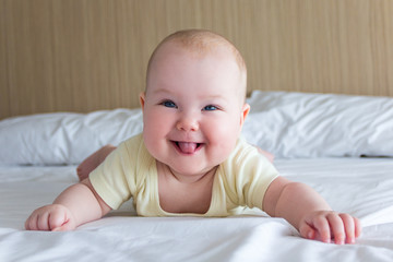portrait of funny and happy little baby lying on the bed