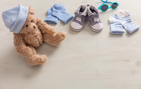 Baby boy shoes and socks on wooden background