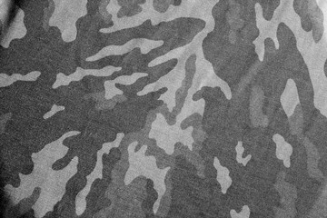 Old camouflage cloth with blur effect in black and white. © pavelalexeev