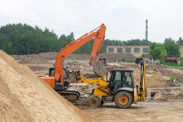 Excavator and tractor on the construction site