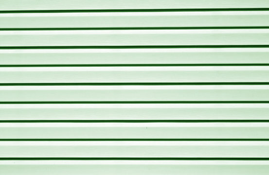 Plastic siding surface in green tone.