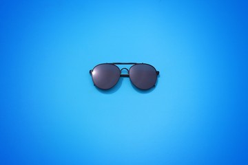 sunglasses on blue background , eyeglass top view 