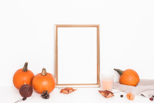Autumn composition. Photo frame, pumpkins, candles, dried leaves on white background. Autumn, fall, halloween concept. Front view, copy space