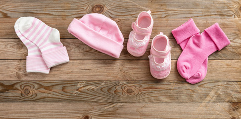 Baby girl shoes and socks on wooden background