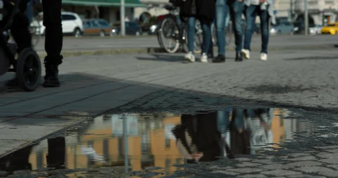People walking and bicycling passed a puddle in Stockholm harbour