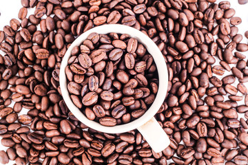 Cup of coffee full of coffee beans from top view