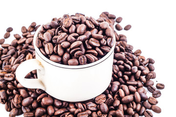 Cup of coffee full of coffee beans isolated on white background, side view