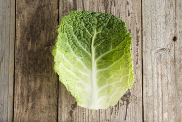 Healthy food and dieting concept. One brassica leaf isolated over rustic wooden background....