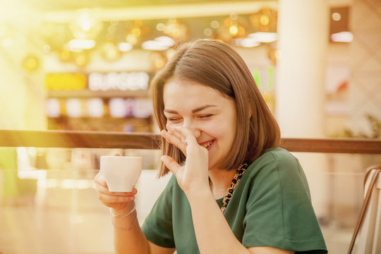 Portrait of beautiful smiling young woman with coffee cup in coffee. Communication and friendship concept.