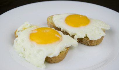 Two sandwiches with egg on a white plate.