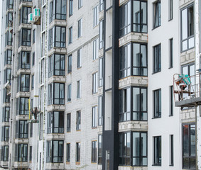 A multi-storey building under construction. Work is carried out on the facade.