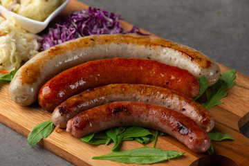Grilled sausages with mash potatoes on wooden board
