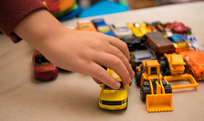 Naklejka premium Set of toy cars and the hand of a little boy.