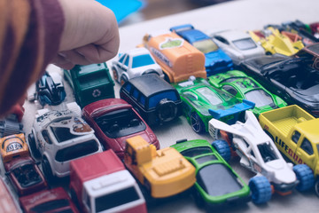 Set of toy cars and the hand of a little boy.