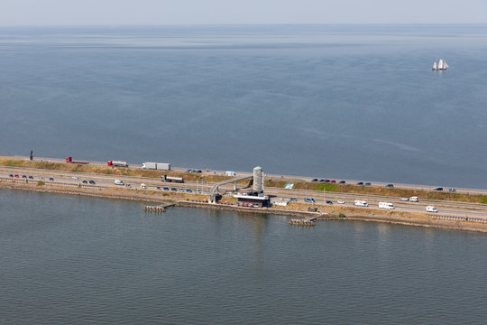 Aerial view Dutch afsluitdijk with watchtower and monument ir. Lely. The dam is the separation between the fresh water lake IJsselmeer and the salt Wadden Sea