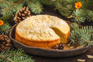 Traditional Christmas (Norwegian) almond pie in Christmas decorations, dark background.