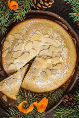 Traditional Christmas (Norwegian) almond pie in Christmas decorations, dark background.