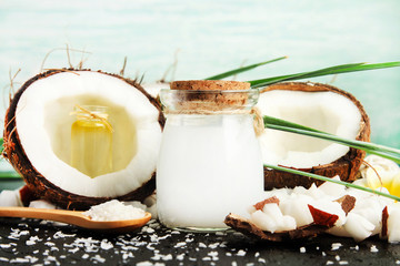 Coconut milk glass jar with nuts and oil bottles, fresh coconut flakes. Homemade skin & beauty care...
