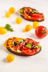 Sandwiches with tomatoes and cheese on white background, top view.