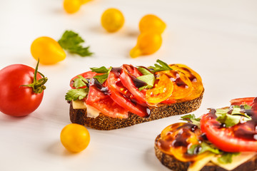 Sandwiches with tomatoes and cheese on white background, top view.