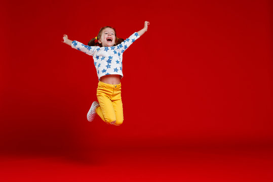 Funny Child Girl Jump In Glasses On Colored Background