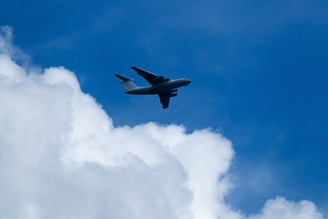 Blue sky with clouds and flying airplane