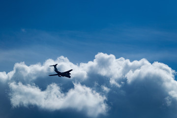 Blue sky with clouds and flying airplane