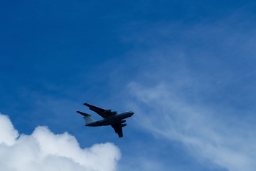 Blue sky with clouds and flying airplane