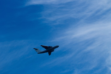 Blue sky with clouds and flying airplane