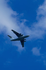 Blue sky with clouds and flying airplane