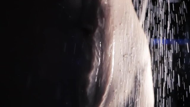 Water sprays fall on the wet body, splashing and flowing down in slow motion. Silhouette of attractive woman taking shower in dark bathroom. Passion, beauty and temptation concept. Bodycare background