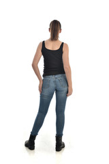 Obraz premium full length portrait of brunette girl wearing black single and jeans. standing pose with back to the camera. isolated on white studio background.