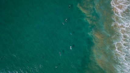 Surfers on beautiful day enyouing the waves in Australia, photographed from above using a drone.