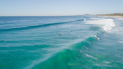 Surfers on beautiful day enyouing the waves in Australia, photographed from above using a drone.