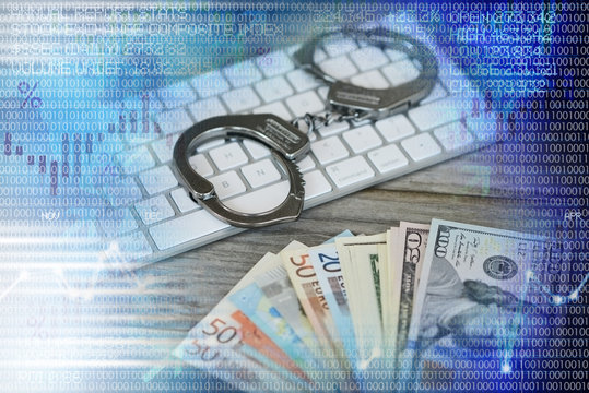 Handcuffs on computer keyboard with cash money and abstract background, concept of condemnation for online fraud

