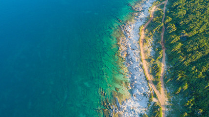 Fototapeta premium Drone shot of a rocky headland at daylight with emerald color water