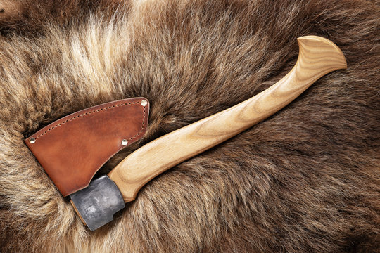 Hatchet on bear skin. Metal ax on a bear hide.