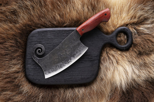 Hatchet on bear skin. Metal ax on a bear hide.