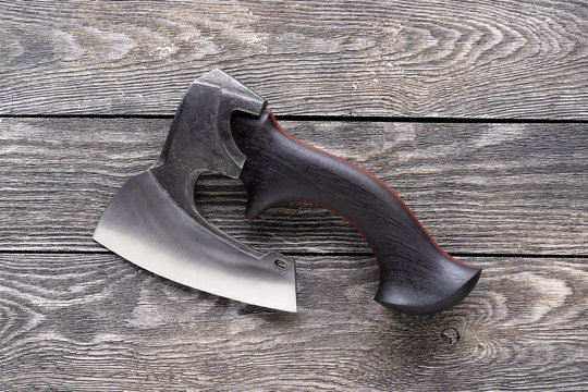 Hatchet on a wood deck. Metal ax on a wood