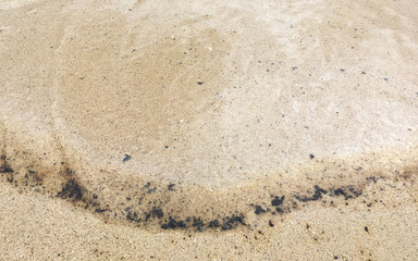 Oil spill on the sand beach