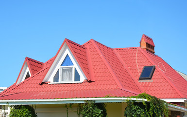 Valley and gable roofing construction with attic windows,  rain gutter, waterproofing. Roof gutter...