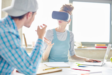 Busy startup partners gesturing hands while discussing new project, young woman in virtual reality...