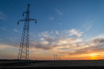 Rural landscape with high-voltage line on sunset