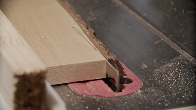 Cutting wooden plank by electric saw in UHD