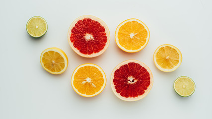 top view of fresh grapefruit, lemon, lime and orange slices, on grey